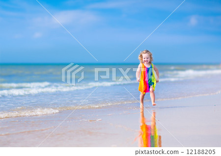 Little girl running on a beach Little girl running on a beach 12188205