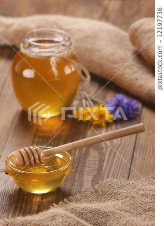 honey in a glass bowl on a wooden boards background honey in a glass bowl on a wooden boards background 12197736