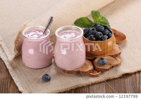 yogurt with blueberries in a glass jar and blueberries in a wood yogurt with blueberries in a glass jar and blueberries in a wood 12197799