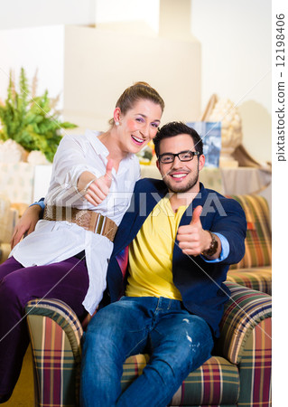 Couple buying armchair in furniture store 12198406