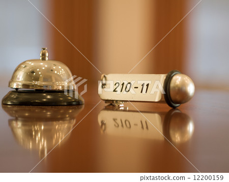 Hotel bell and key lying on the desk 12200159