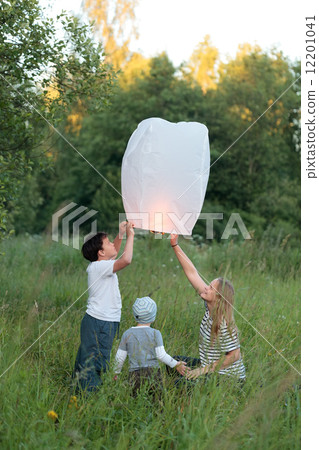 Family of three flying paper lantern outdoor 12201041