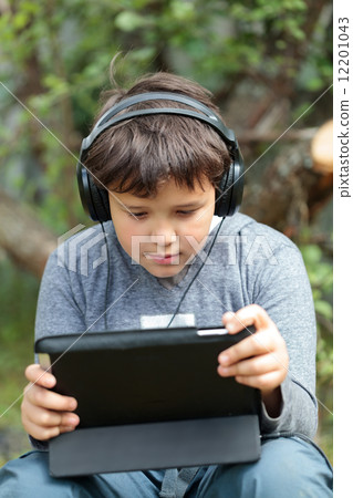 Teen boy in headphones with pad 12201043