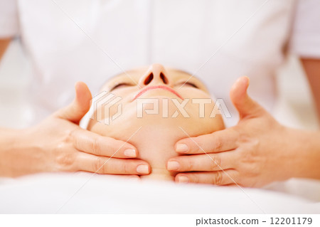 Woman under facial treatment at beauty spa 12201179