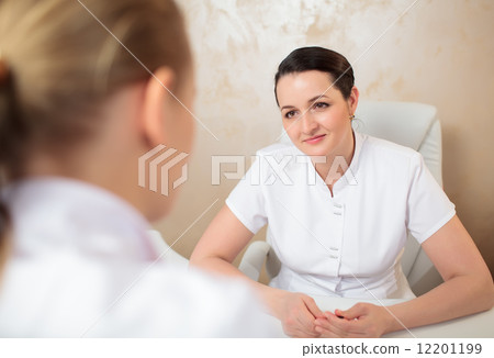 Talk of two female cosmeticians in the office room Talk of two female cosmeticians in the office room 12201199