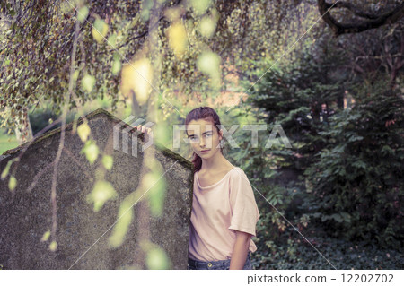 vintage shoot of a woman touching a moss overgrown tombstone vintage shoot of a woman touching a moss overgrown tombstone 12202702