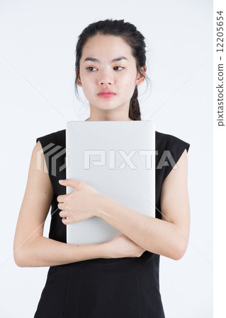 Asian business woman holding a laptop, standing Asian business woman holding a laptop, standing 12205654