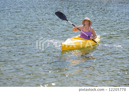 Woman Kayaking on Beautiful Mountain Lake. 12205778
