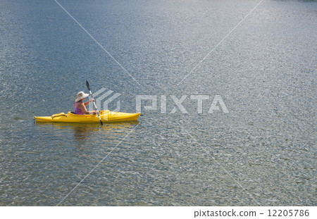 Woman Kayaking on Beautiful Mountain Lake. 12205786