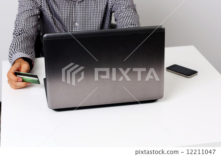 Portrait ofca man using credit card and laptop to shop online 12211047