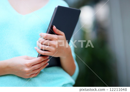 Closeup portrait of a woman holding tablet computer 12211048