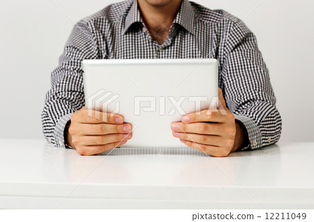 Man sitting on the table and holding tablet computer 12211049