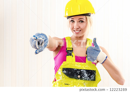 Woman in coverall and hard hat showing thumbs up Woman in coverall and hard hat showing thumbs up 12223289