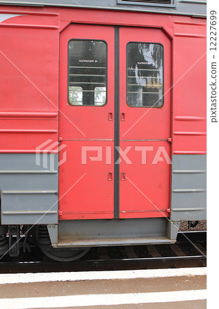 Red doors of a carriage of an electric train at the platform Red doors of a carriage of an electric train at the platform 12227699