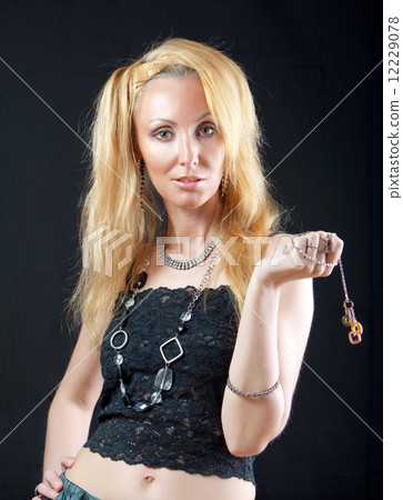 beautiful young blonde woman with long hair and jewellery on dark background... 12229078