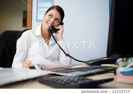 Portrait of young businesswoman talking on phone in office Portrait of young businesswoman talking on phone in office 12233717