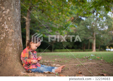 A girl leaning on a tree 12234083