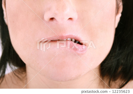 an embarrassed woman biting on her lip 12235623