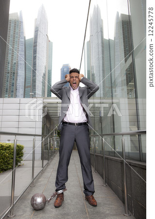 Businessman with shackles outdoors 12245778