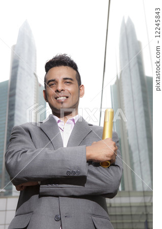 Asian businessman holding gold baton outdoors 12245843