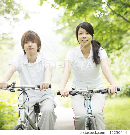 A couple riding a bicycle 12250444