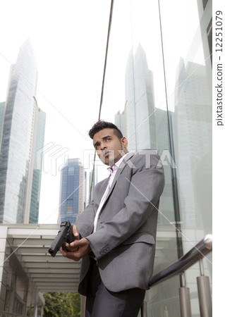 Businessman holding gun outdoors Businessman holding gun outdoors 12251079