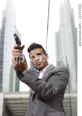 Businessman holding gun outdoors Businessman holding gun outdoors 12251082