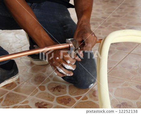 cutting a copper pipe with a pipe cutter 12252138