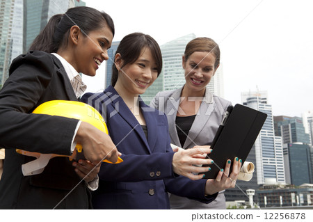 Businesswomen looking at tablet outside Businesswomen looking at tablet outside 12256878