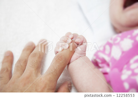 Baby's hand holding a finger's fingers 12258553