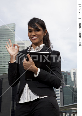 Businesswoman making OK hand gesture outdoors 12262041