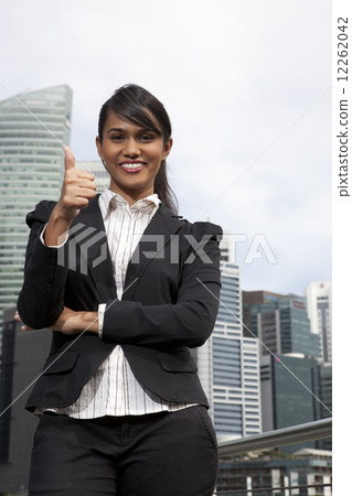 Businesswoman giving the thumbs up sign outdoors 12262042