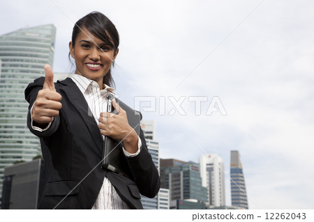 Businesswoman giving the thumbs up sign outdoors 12262043