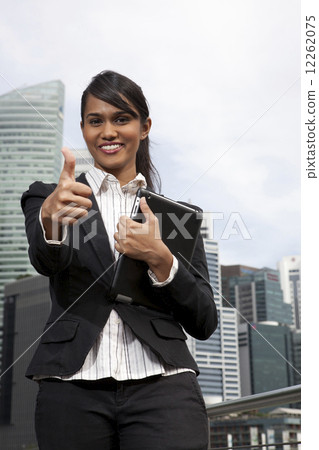 Businesswoman giving the thumbs up sign outdoors Businesswoman giving the thumbs up sign outdoors 12262075