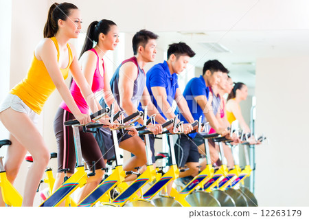 Asian people in spinning bike training at fitness gym 12263179