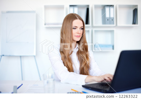Portrait of beautiful young smiling business woman working on a Portrait of beautiful young smiling business woman working on a 12263322