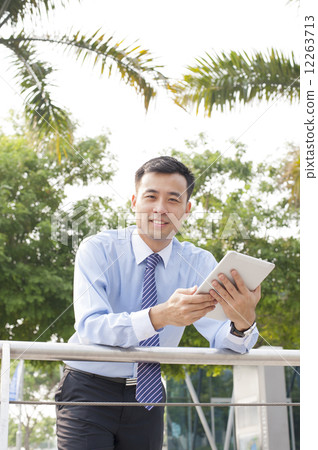 Asian business executive using a tablet. Asian business executive using a tablet. 12263713