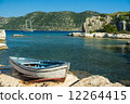 An old fishing boat moored at Simena peninsula with an ancient i 12264415