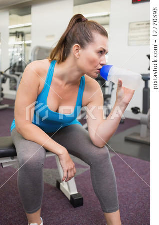 Fit brunette drinking from sports bottle 12270398