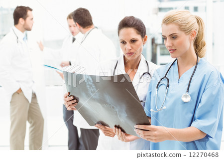 Female doctors examining x-ray Female doctors examining x-ray 12270468