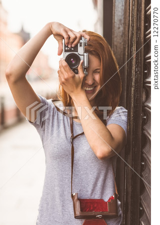 Pretty redhead taking a picture with retro camera Pretty redhead taking a picture with retro camera 12270770