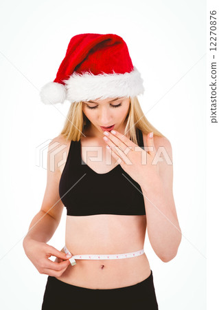 Fit festive young blonde looking at measuring tape 12270876