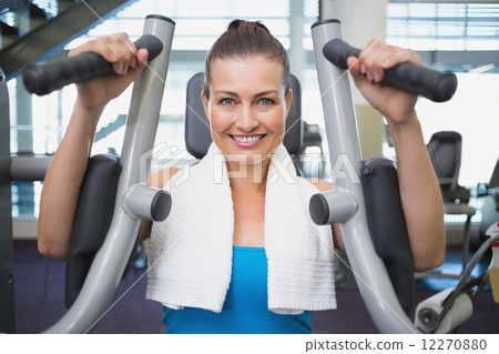 Fit brunette using weights machine for arms 12270880