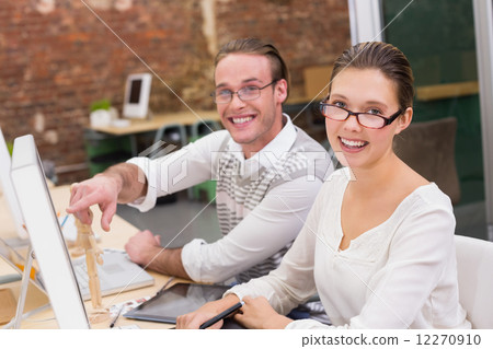 Smiling photo editors using computer in office Smiling photo editors using computer in office 12270910