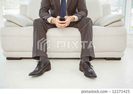 Low section of businessman text messaging 12271425