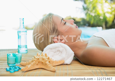 Beautiful woman lying on massage table at spa center Beautiful woman lying on massage table at spa center 12271467