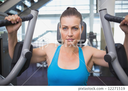 Fit brunette using weights machine for arms Fit brunette using weights machine for arms 12271519