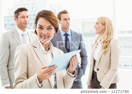 Businesswoman using digital tablet with colleagues behind Businesswoman using digital tablet with colleagues behind 12271780