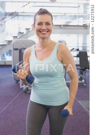 Fit brunette working out with dumbbells  12271912