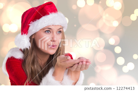 Composite image of festive blonde blowing over hands Composite image of festive blonde blowing over hands 12274413